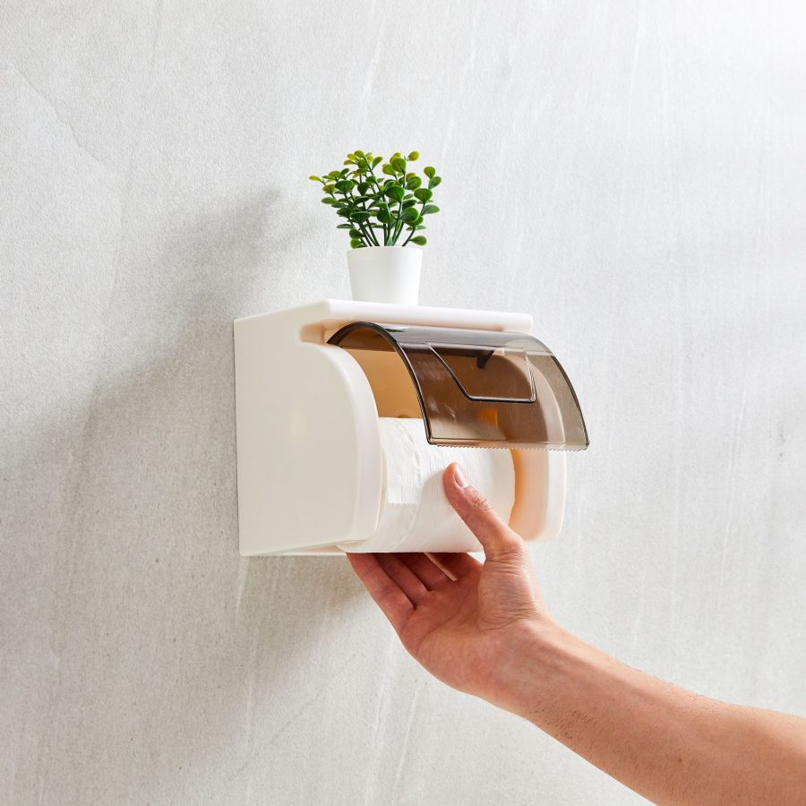Wall mounted tissue roll holder with storage shelf and smoke cover installed on bathroom wall